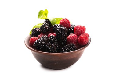 Ahududu, böğürtlen ve nane yaprağı seramik kahverengi kâsede beyaz arka planda izole edilmiş..  