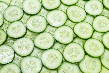 Arka plan olarak taze yeşil salatalık dilimleri. Üst görünüm. 