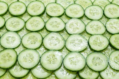 Arka plan olarak taze yeşil salatalık dilimleri. Üst görünüm. 