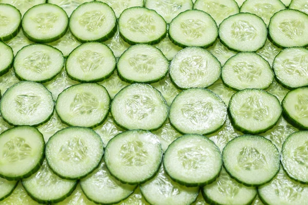 Arka plan olarak taze yeşil salatalık dilimleri. Üst görünüm. 