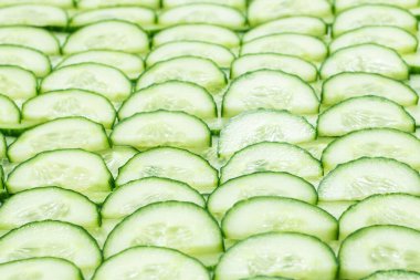 Arka plan olarak taze yeşil salatalık dilimleri. Üst görünüm. 