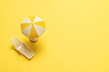 Sarı arka planda güneş ışığı ve sarı şemsiye..