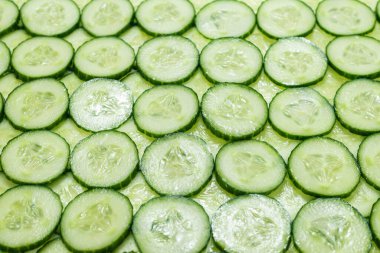 Arka plan olarak taze yeşil salatalık dilimleri. Üst görünüm. 