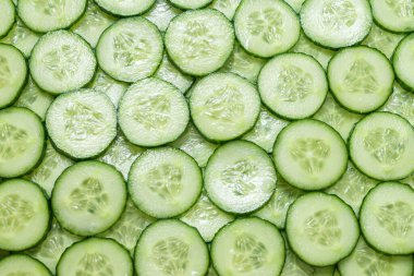 Arka plan olarak taze yeşil salatalık dilimleri. Üst görünüm. 