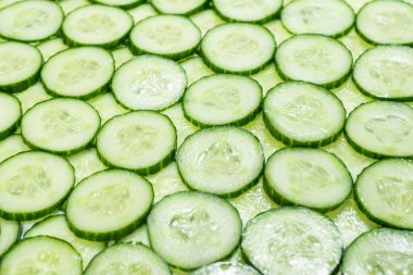 Arka plan olarak taze yeşil salatalık dilimleri. Üst görünüm. 