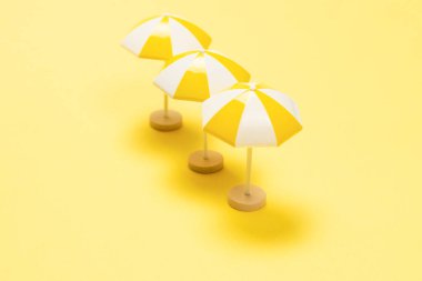 Sarı arka planda güneş ışığı ve sarı şemsiye..