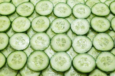 Arka plan olarak taze yeşil salatalık dilimleri. Üst görünüm. 