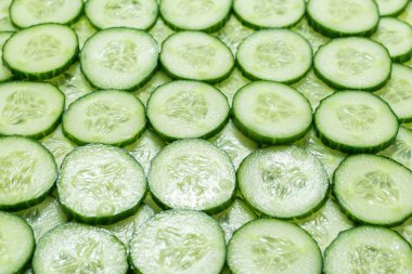 Arka plan olarak taze yeşil salatalık dilimleri. Üst görünüm. 