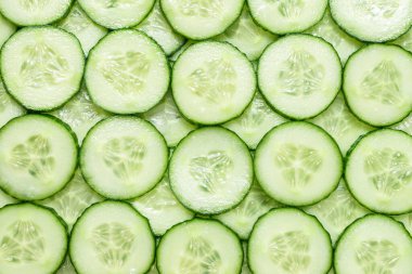 Arka plan olarak taze yeşil salatalık dilimleri. Üst görünüm. 