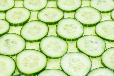 Arka plan olarak taze yeşil salatalık dilimleri. Üst görünüm. 