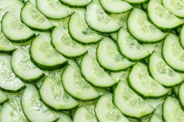 Arka plan olarak taze yeşil salatalık dilimleri. Üst görünüm. 