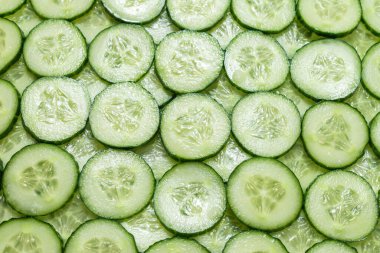 Arka plan olarak taze yeşil salatalık dilimleri. Üst görünüm. 