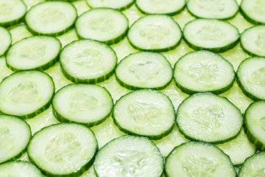 Arka plan olarak taze yeşil salatalık dilimleri. Üst görünüm. 