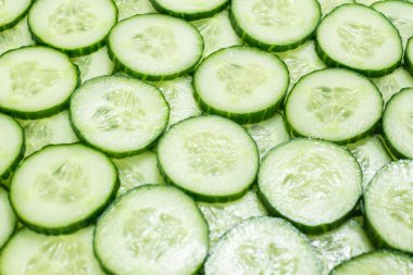 Arka plan olarak taze yeşil salatalık dilimleri. Üst görünüm. 