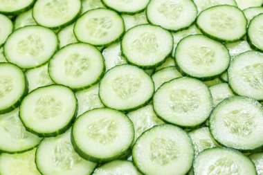 Arka plan olarak taze yeşil salatalık dilimleri. Üst görünüm. 