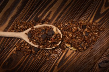 Tahta kaşıkta fındıklı çikolatalı tahıl gevreği. Ahşap bir arka planda.