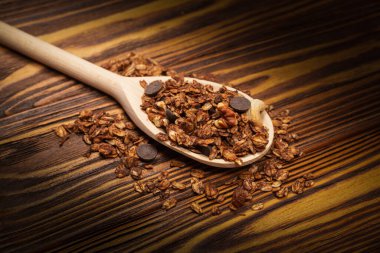 Tahta kaşıkta fındıklı çikolatalı tahıl gevreği. Ahşap bir arka planda.