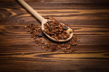 Tahta kaşıkta fındıklı çikolatalı tahıl gevreği. Ahşap bir arka planda.