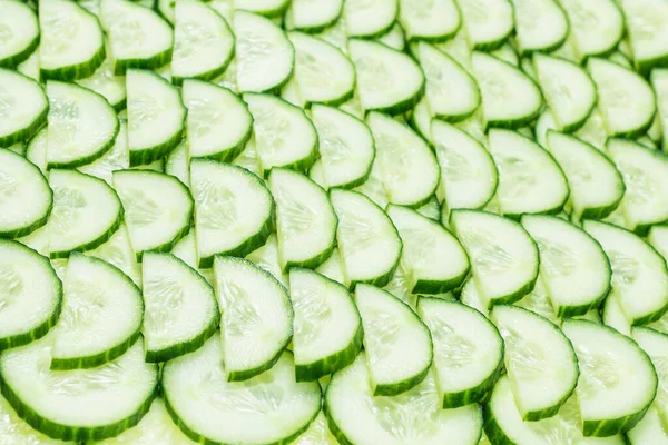 Fresh green slices of cucumber as background. Top view.