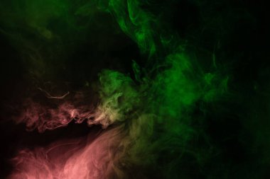 Siyah arka planda yeşil ve pembe buhar. Boşluğu kopyala.