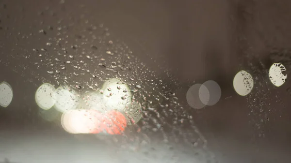 带雨滴和灯光的模糊背景 — 图库照片