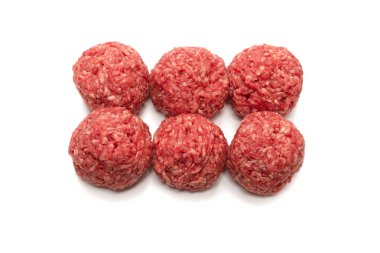Beyaz arkaplanda çiğ et topları izole.