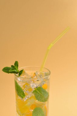 Bej arka planda limonlu ve naneli kokteyl. Boşluğu kopyala.  