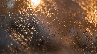 Yağmur damlaları ve ışıklarla bulanık arkaplan.