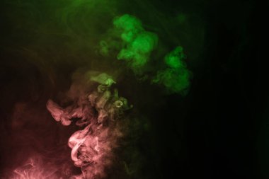 Siyah arka planda yeşil ve pembe buhar. Boşluğu kopyala.