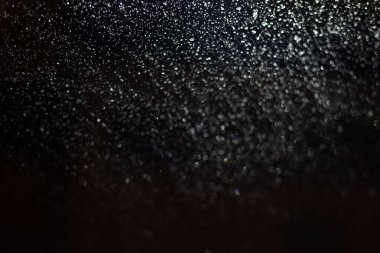 Yağmur damlaları ve ışıklarla bulanık arkaplan.