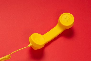 Kırmızı arkaplanda sarı cep telefonu. 