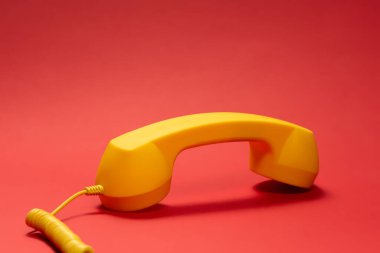 Kırmızı arka planda sarı cep telefonu. Boşluğu kopyala. 