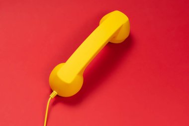 Kırmızı arka planda sarı cep telefonu. Boşluğu kopyala. 
