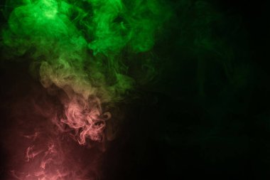 Siyah arka planda yeşil ve pembe buhar. Boşluğu kopyala.