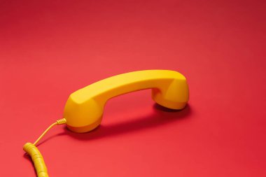 Kırmızı arka planda sarı cep telefonu. Boşluğu kopyala. 