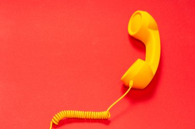 Kırmızı arkaplanda sarı cep telefonu. 