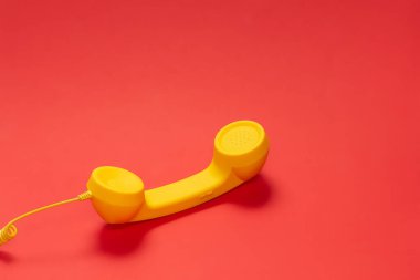 Kırmızı arkaplanda sarı cep telefonu. 
