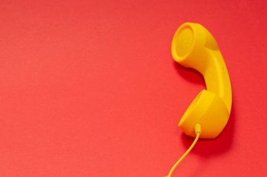 Kırmızı arkaplanda sarı cep telefonu. 