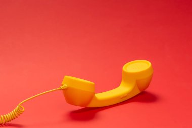 Kırmızı arkaplanda sarı cep telefonu. 