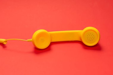 Kırmızı arkaplanda sarı cep telefonu. 