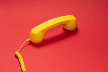 Kırmızı arka planda sarı cep telefonu. Boşluğu kopyala. 