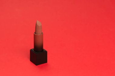 Kırmızı arka planda kırmızı ruj. Kadınlar için makyaj. 