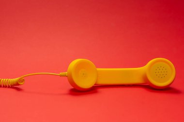 Kırmızı arkaplanda sarı cep telefonu. 