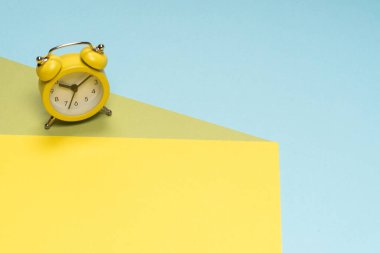 Sarı, mavi ve yeşil arka planda sarı alarm saati. Uzayı kopyala Zaman kavramı. 