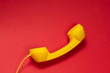 Kırmızı arka planda sarı cep telefonu. Boşluğu kopyala. 