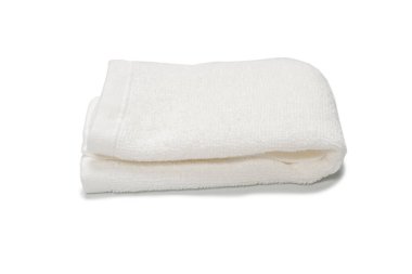 Beyaz arka planda izole edilmiş beyaz pamuklu havlu. Spa ve tatil köyü. 