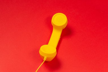Kırmızı arkaplanda sarı cep telefonu. 