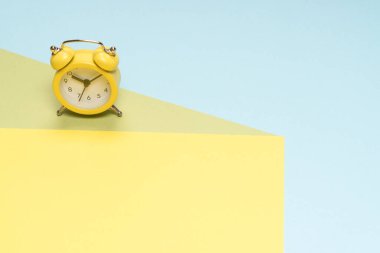 Sarı, mavi ve yeşil arka planda sarı alarm saati. Uzayı kopyala Zaman kavramı. 