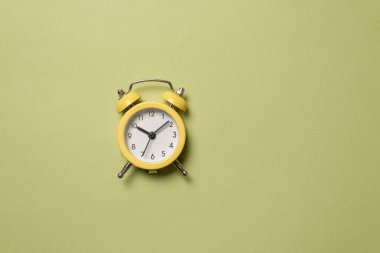 Yeşil arka planda sarı alarm saati. Uzayı kopyala Zaman kavramı. 