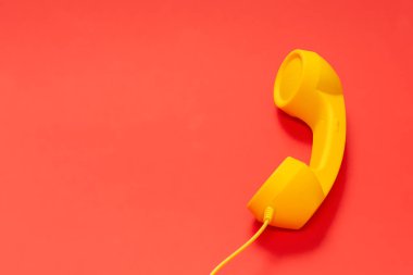Kırmızı arkaplanda sarı cep telefonu. 